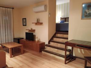 sala de estar con escaleras, TV y sofá en Hotel Palaterna, en Pastrana