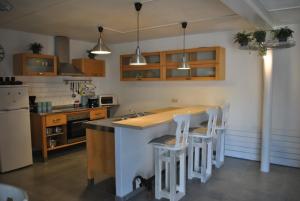 a kitchen with a island with stools in it at Le gîte du Loup in Couvin