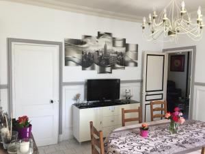 una sala da pranzo con un tavolo e un lampadario di maison de maitre a Fleury-sur-Andelle