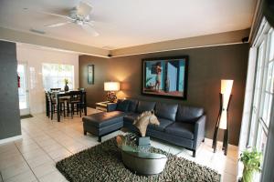 a living room with a leather couch and a dining room at Coral Reef Guesthouse in Fort Lauderdale