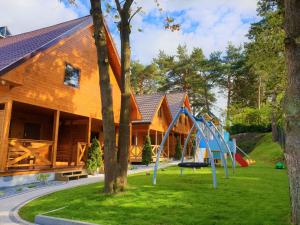 a playground in front of a wooden house at ALKADO Jastrzebia Gora in Jastrzębia Góra