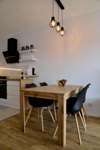 uma sala de jantar com uma mesa de madeira e cadeiras em Apartament Gdańsk Baltica Towers 7floor em Gdansk