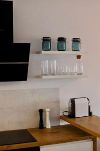 a kitchen with glasses on shelves and a counter at Apartament Gdańsk Baltica Towers 7floor in Gdańsk