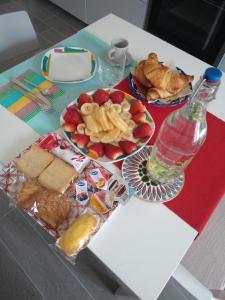 einen Tisch mit Teller mit Lebensmitteln und einer Flasche Wasser in der Unterkunft B&B Lambda in Salerno