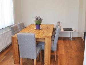 un tavolo in legno con sedie e una pianta in vaso. di Villa Kubus a Langenargen