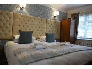 a bedroom with a large bed with towels on it at Ashlea Guest House in Banbury