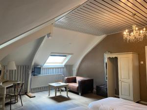 a bedroom with a bed and a couch and a table at Frissestein in Deil