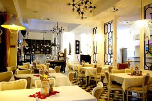 restauracja ze stołami i krzesłami oraz białymi stołami i krzesłami w obiekcie Hotel Ottaviano w Świnoujściu