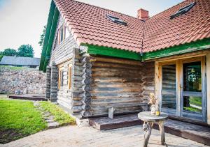 a wooden house with a table in front of it at Viesu māja ar saunu "Lankalni" in Dzelda +9 photos
