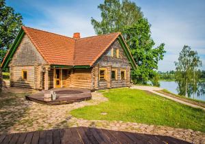 a log cabin with a large yard in front of a lake at Viesu māja ar saunu "Lankalni" in Dzelda