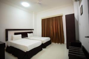 Habitación de hotel con 2 camas y ventana en Star Emirates Furnished Apartment, en Salalah