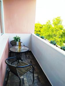 una pequeña mesa y sillas en un balcón con ventana en Lora Apartman en Nyíregyháza