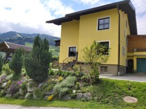 a yellow house with a garden in front of it at Haus Silvia Kraml in Schladming