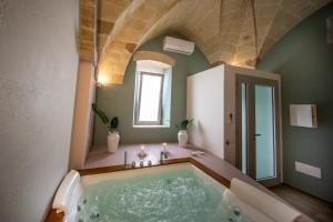 een badkamer met een groot bad in een kamer bij Liconti Exclusive Rooms in Pulsano
