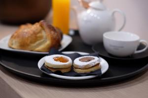 a plate with two pastries and a cup of coffee at ALMA ROOM in Santa Maria Capua Vetere