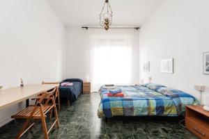 a bedroom with a bed and a desk and a table at A Due Passi Dal Treno in Pisa