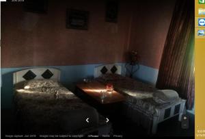 Bahar E Madina Mansehra في Chitta Batta: غرفة نوم بسريرين وطاولة فيها