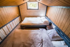 a small room with two beds and a window at Jomantų slėnis in Jomantai