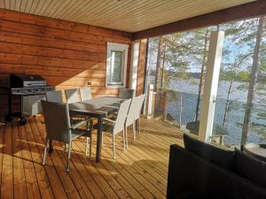 a dining room with a table and chairs on a deck at Ulpukkaranta in Ähtäri