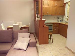 a living room with a couch and a kitchen at Angel in Oropos