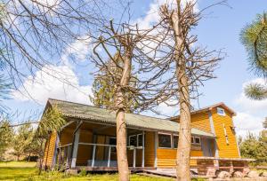 a yellow house with trees in front of it at Jomantų slėnis in Jomantai