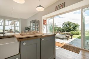 a kitchen with a counter and a large window at Ty Carmel - Carmel House in Llanerchymedd
