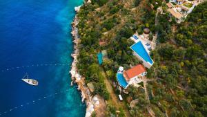 an island with a house and a boat in the water at Hotel Villa Mahal in Kalkan