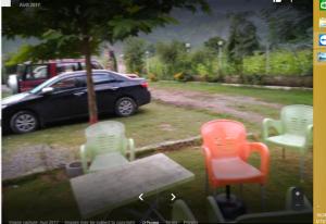 a view of chairs and a car in a yard at Hotel Royal Park in Hassa