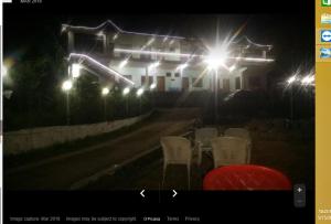 a table and chairs in front of a building with lights at Hotel Royal Park in Hassa