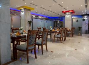 a dining room with wooden tables and chairs at Jazan Inn Hotel in Jazan