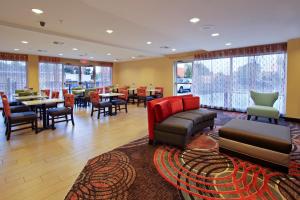 Holiday Inn Express Augusta Downtown, an IHG Hotel في أوغوستا: لوبي به طاولات وكراسي ومطعم