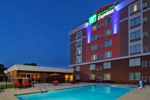 a hotel with a pool in front of it at Holiday Inn Express Augusta Downtown, an IHG Hotel in Augusta