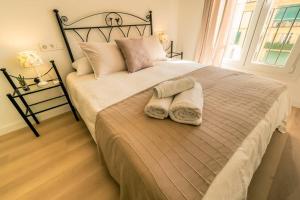 een slaapkamer met een groot bed en handdoeken bij TGH/ Malagueta paradise II in Málaga