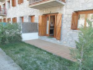 Cette maison dispose de portes en bois et d'une terrasse. dans l'établissement B25 - La Granja, Bajo con jardín - Villmor, à Benasque