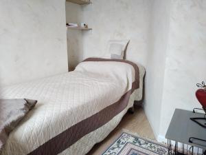 two beds in a small room with a table at Le studio côté chapelle in Coursegoules