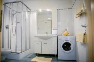 a bathroom with a washing machine and a sink at Appartements Kirchtalhof in Lana