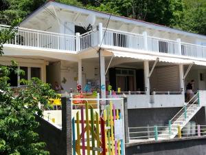 a house with a balcony with a bunch of colorful equipment at ESCALE CREOLE in Terre-de-Haut