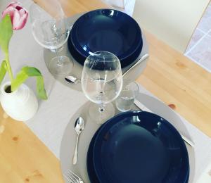 a table with blue plates and wine glasses on it at Lille hygge in Leck +23 photos