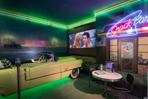 a car themed room with a table and a tv at Victorian Mansion At Los Alamos in Los Alamos