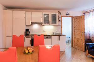 een keuken met een tafel en oranje stoelen in een kamer bij Ferienwohnung "Johann" in Meckenbeuren