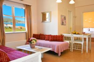 Habitación con cama, mesa y ventana en Andros Apartment - Lasia en Andros
