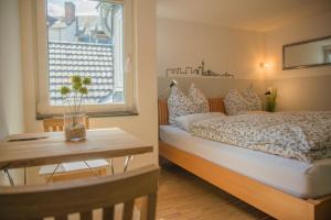 a bedroom with a bed and a table and a window at Altstadt Apartment Centralissimo in Düsseldorf