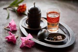 a tray with a drink and a bowl of food and flowers at Hotel Villa Mahal in Kalkan