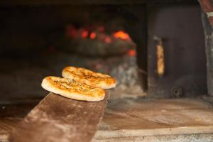 two pizzas are sitting on a table in an oven at Hotel Villa Mahal in Kalkan