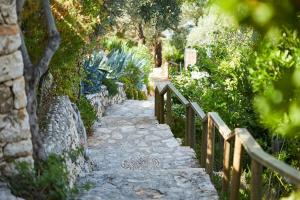 a stone path in a garden with a fence at Hotel Villa Mahal in Kalkan