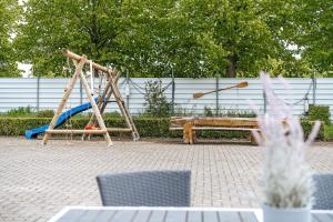 a playground with a bench and a swing at Apartments Am Erdbeerhof in Rövershagen