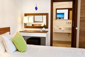 a bedroom with a bed with a desk and a sink at Hotel Villa Mahal in Kalkan