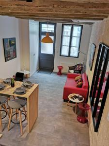 uma sala de estar com um sofá vermelho e uma mesa em Maison de Ville au Cœur du Quartier Historique em Tours