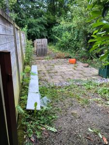 a garden with a bench and a fence at L' Annexe Beverl'inn in Flers