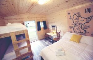 a bedroom with a bed in a wooden cabin at Firehouse Campground in Hill City